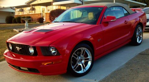 2006 Ford Mustang - A red 2006 Ford Mustang GT convertible is parked in front of a house.