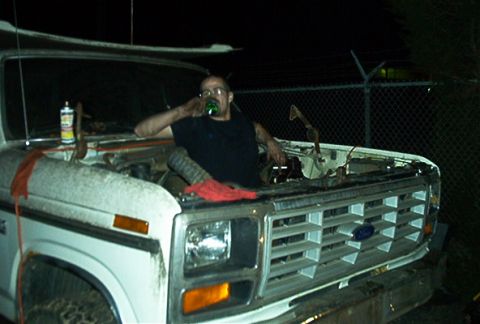 1979 Ford Bronco - Night shot of a white 1980s Ford truck/Bronco front clip with the hood removed, exposing the radiator support and engine bay while a man in…
