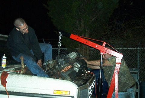 1979 Ford Bronco - Engine hoist lifting an engine out of a truck bed at night.