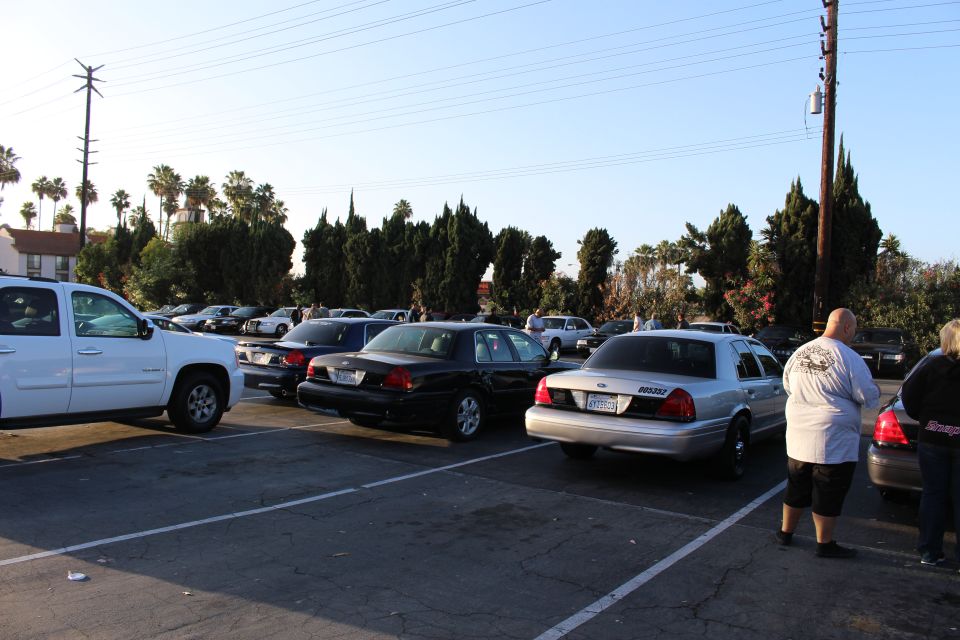 White SUV and silver Ford sedan in a parking lot with a person standing at right