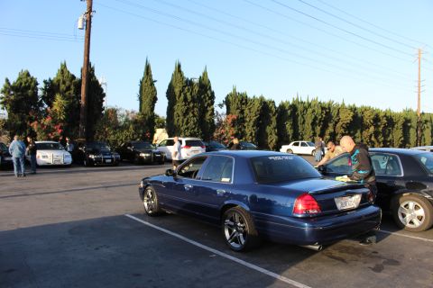 2003 Ford Crown Victoria - dark blue Ford Crown Victoria on chrome wheels parked at a meet as people gather around sedans across the lot.