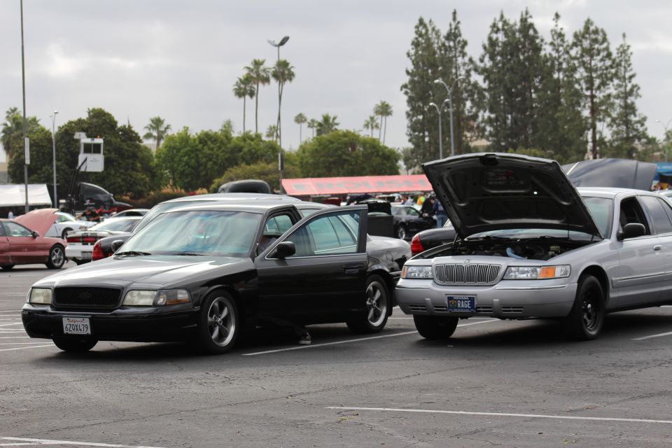 Black Mercury sedan and silver Mercury with open hood in lot
