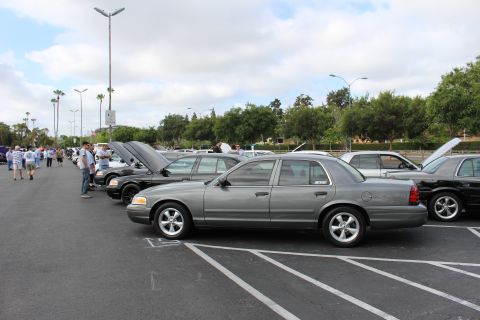 2003 Ford Crown Victoria - gray Ford Crown Victoria sedan shown in side profile parked in a lot lined with other full-size sedans, hoods open, at a car meet.