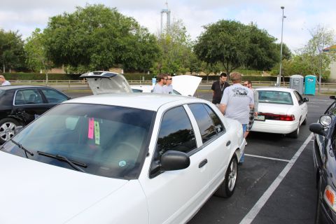 2003 Ford Crown Victoria - white Ford Crown Victoria with display cards on its dashboard parks among other Panther sedans at a meet.
