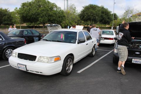 2003 Ford Crown Victoria - white Ford Crown Victoria shows its front three-quarter view among black and white sedans at an outdoor meet.