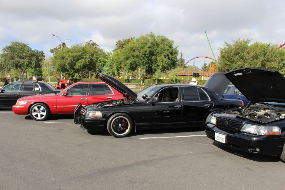 Lowered black sedan and red sedan parked at a car show
