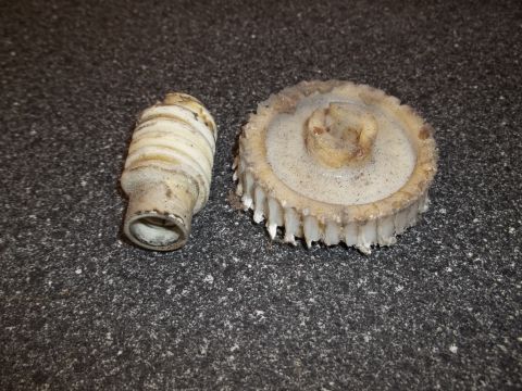 1972 Ford Ranchero - Two plastic automotive parts, a gear and a shaft, are shown on a speckled surface.