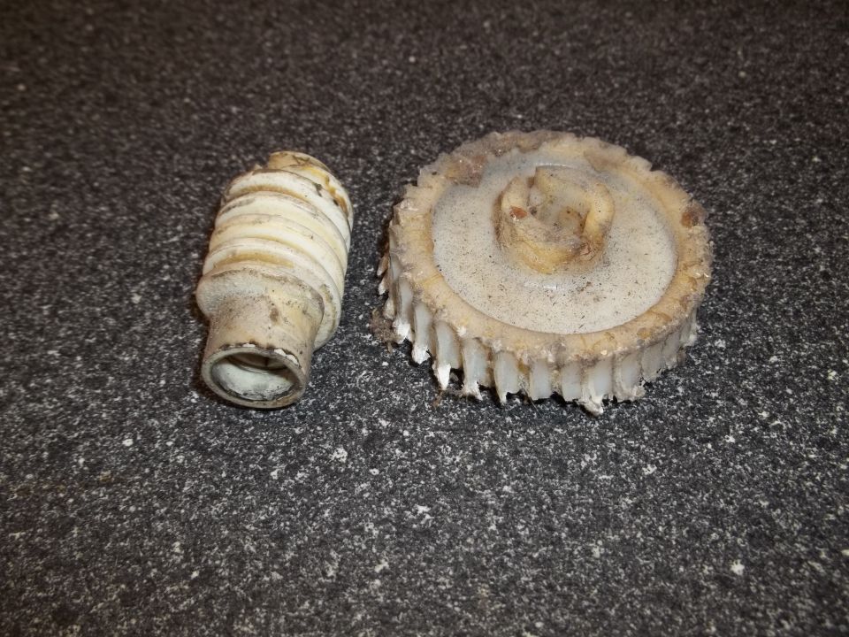 Plastic gear and a ribbed shaft, likely from a car's interior mechanism