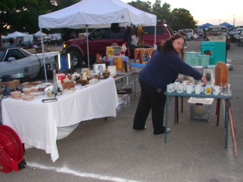 1973 Ford Ranchero - A gray car is parked at a flea market with items displayed on tables nearby.