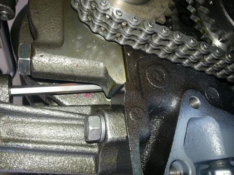 1994 Ford Bronco - Close-up view of engine timing chain and gears, with a hex wrench inserted.