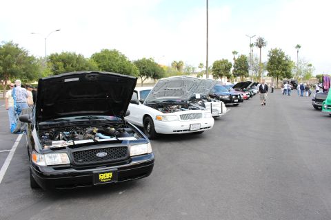 2003 Ford Crown Victoria - black Ford Crown Victoria with raised hood at the head of a row of sedans displayed in a parking lot.