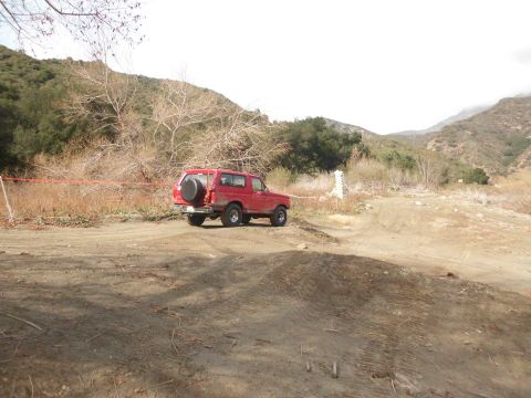 1988 Ford Bronco - Red 1988 Ford Bronco parked in a dry, hilly landscape.
