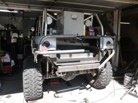1961 International Scout 800 - This heavily modified vehicle, possibly an International Scout, is undergoing extensive body work and customization in a garage setting.