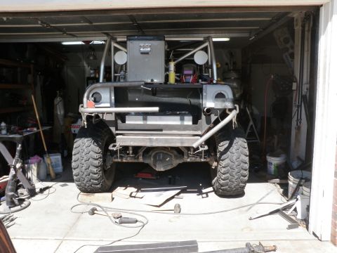 1961 International Scout 800 - This heavily modified vehicle is in a garage, showing its rear end with custom fabrication.
