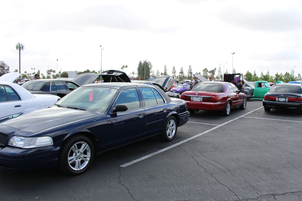 Dark blue Ford sedan parked at an angle with red and green cars behind