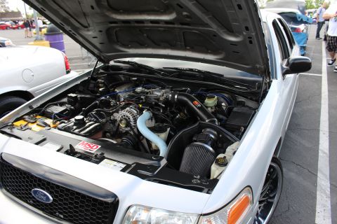 2003 Ford Crown Victoria - open engine bay of a white Ford sedan shows a V8 with aftermarket cold-air intake and an MSD ignition box.