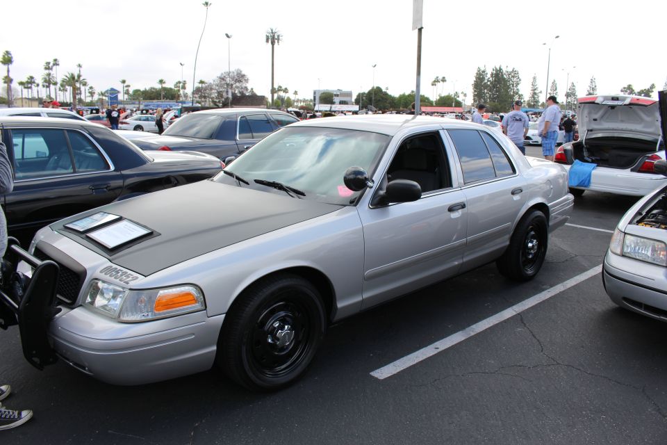 Silver Ford sedan with black steel wheels and matte hood at car show