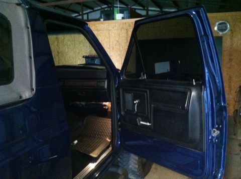 1982 Ford Bronco - Interior view of a blue SUV, revealing a diamond-plate floor mat and dark dashboard details.