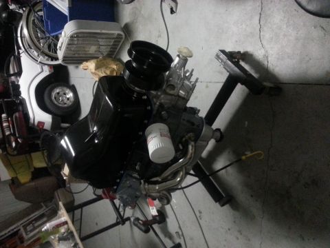 1994 Ford Bronco - Engine assembly on a stand, with a white oil filter and black pulleys visible.