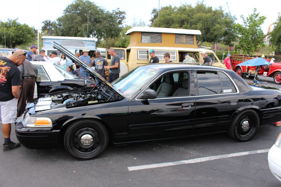 Black Ford sedan with open hood and black steel wheels at car show