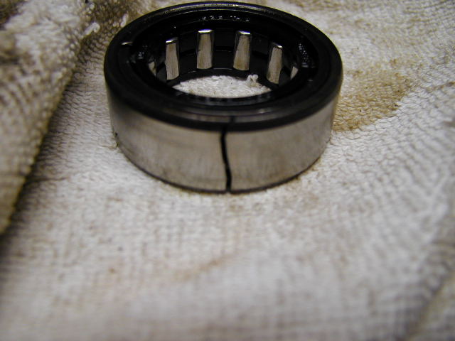 Cracked roller bearing on a white cloth with oil stains