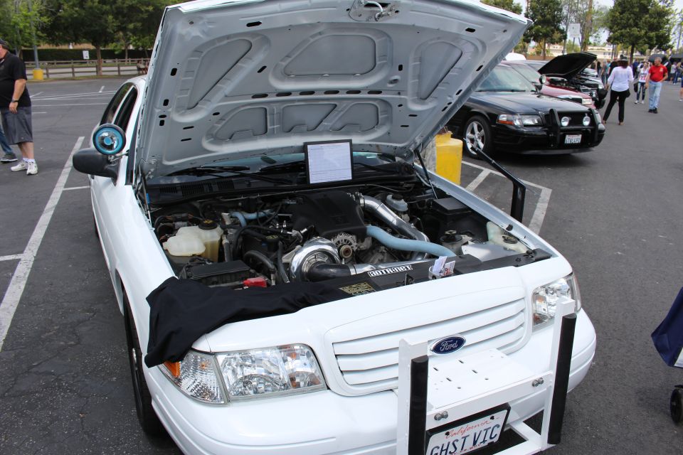 Close view of white Ford sedan engine bay with hood raised
