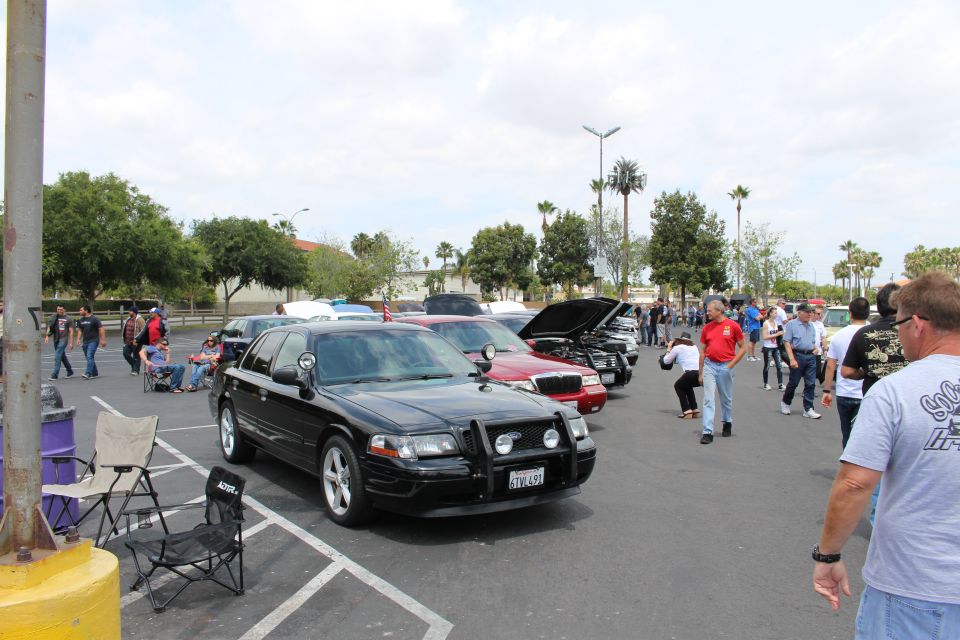 Black sedan with brush guard parked among cars at outdoor meet