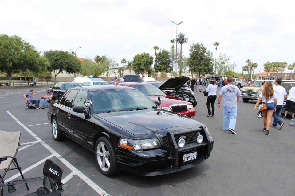 Black sedan with brush guard and gray wheels at parking-lot car show