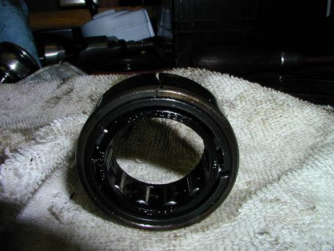 1979 Ford Bronco - A close-up view of a wheel bearing, showing some text imprinted on its surface, resting on a white cloth.