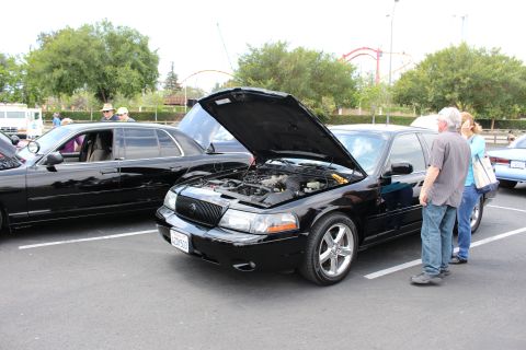 Black Mercury Marauder with hood up, two people viewing the engine bay