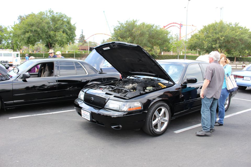 Black Mercury Marauder with hood up, two people viewing the engine bay