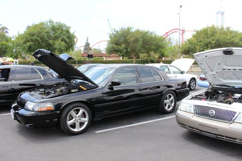 Black Mercury Marauder, hood up, beside a gold Grand Marquis