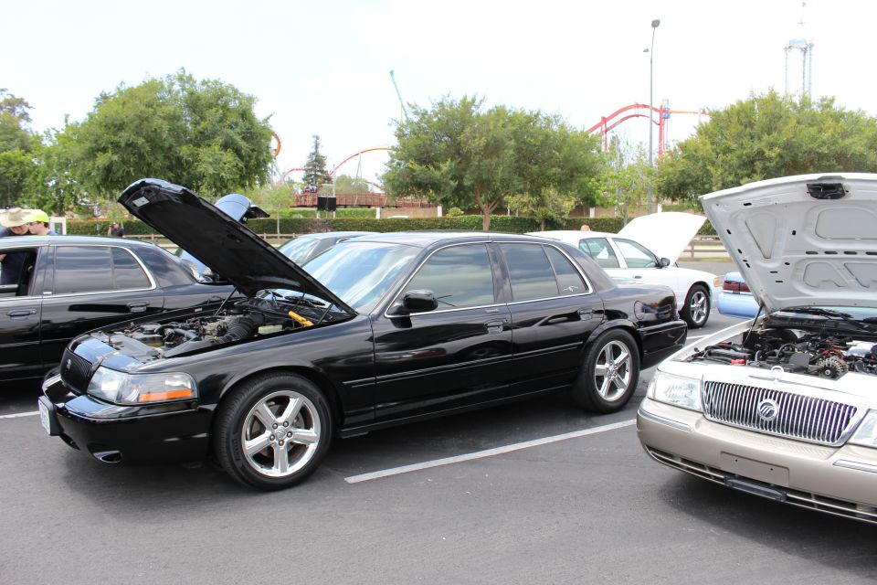 Black Mercury Marauder, hood up, beside a gold Grand Marquis