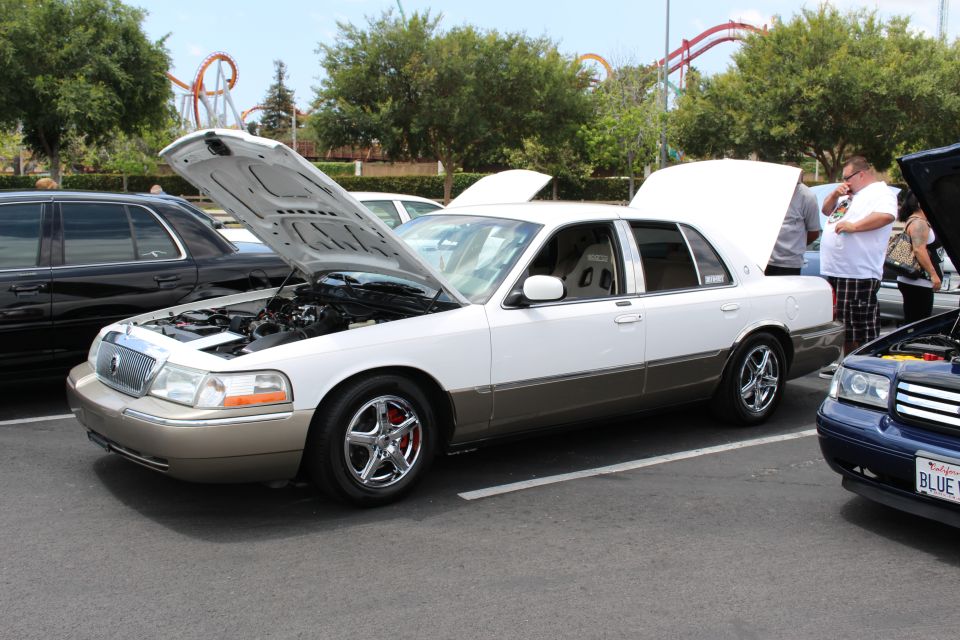 White and gold Mercury Grand Marquis sedan, hood open, at a car show