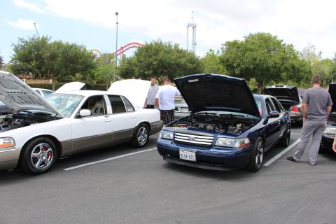 Dark blue Ford Crown Victoria with hood up at an outdoor car show