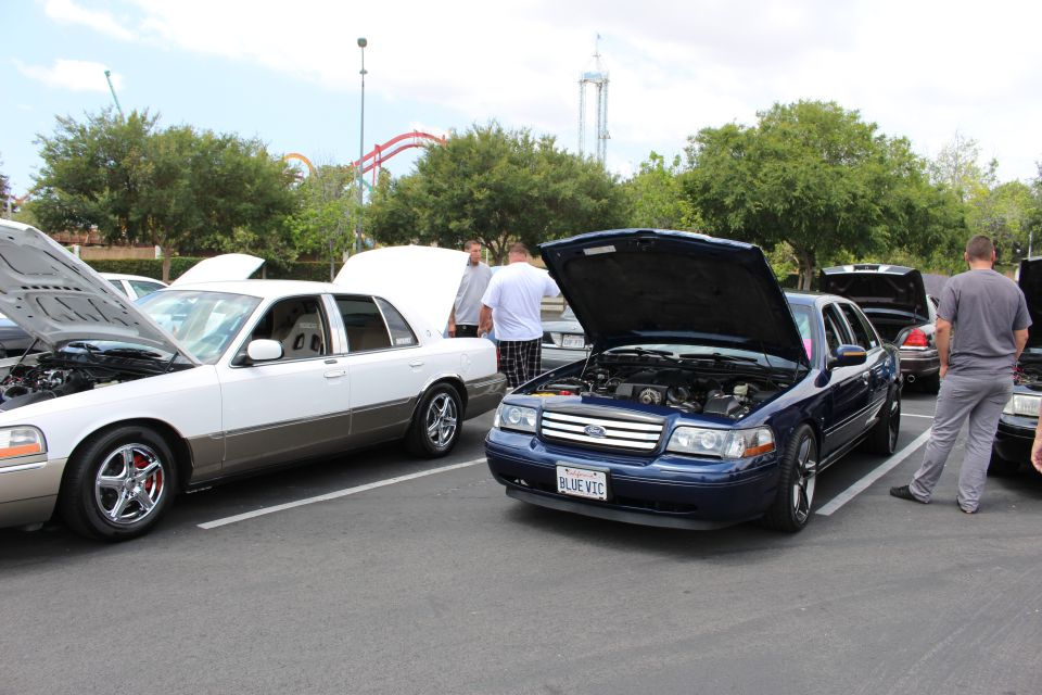 Dark blue Ford Crown Victoria with hood up at an outdoor car show
