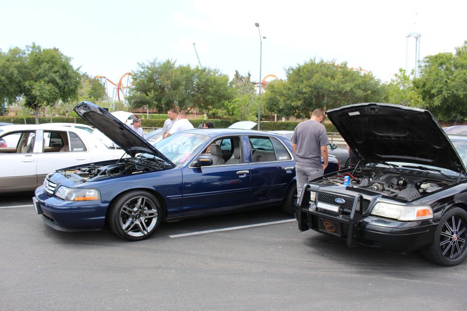 Blue Ford Crown Victoria beside a black police-style Crown Vic, hoods up