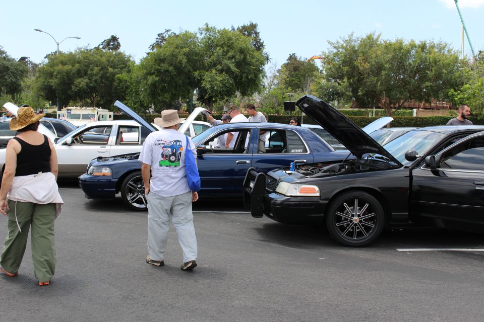 Black Ford Crown Victoria with open hood, spectators in foreground