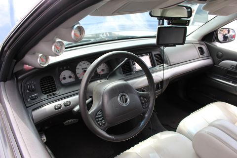 Mercury sedan interior with light leather seats, A-pillar gauges and a center screen