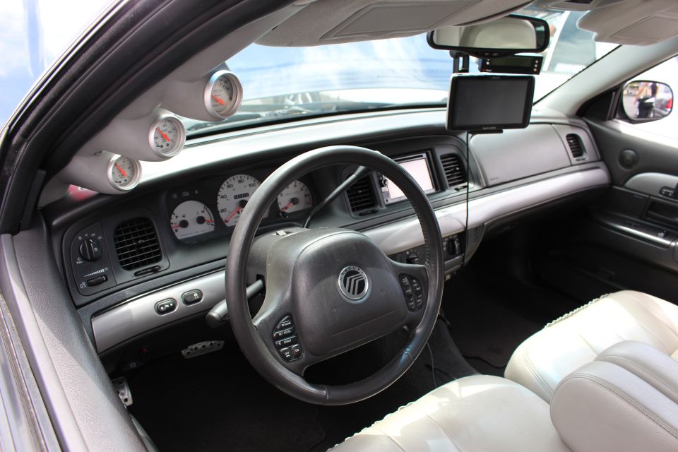 Mercury sedan interior with light leather seats, A-pillar gauges and a center screen