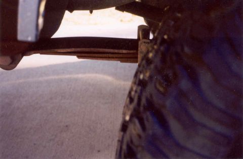 1979 Ford Bronco - Leaf spring and tire detail from an unknown vehicle.
