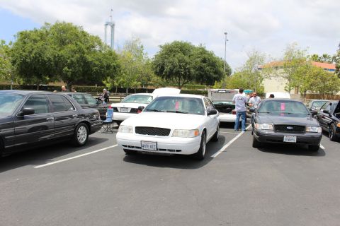 White Ford Crown Victoria with WHITE VIC plate between black and gray Crown Victorias at a show