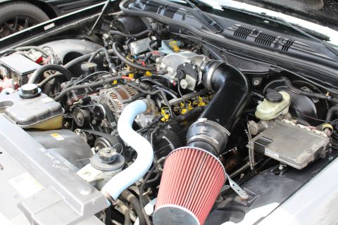 Close-up of V8 engine with red air filter and black intake tubing