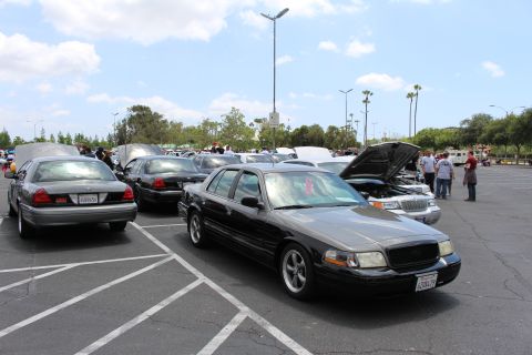 Black two-tone Ford sedan front quarter at a parking-lot car meet
