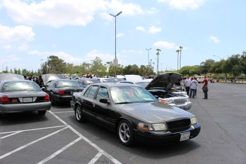 Two-tone black and gray Ford sedan parked among other cars at meet