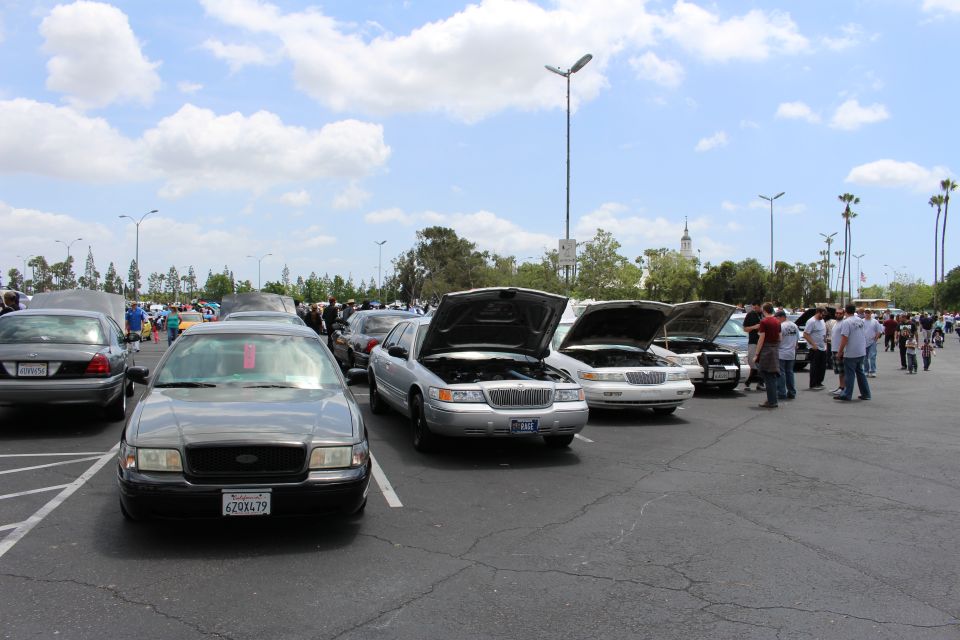 Black Ford sedan and silver Lincoln with hoods up at car meet