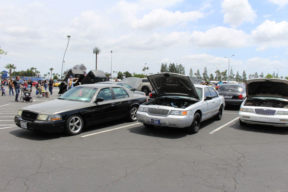 Black sedan, silver Mercury and Lincoln with open hoods at car meet