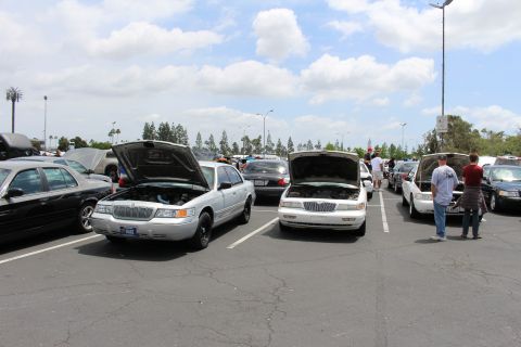Silver Mercury and Lincoln sedans with hoods up at a car meet