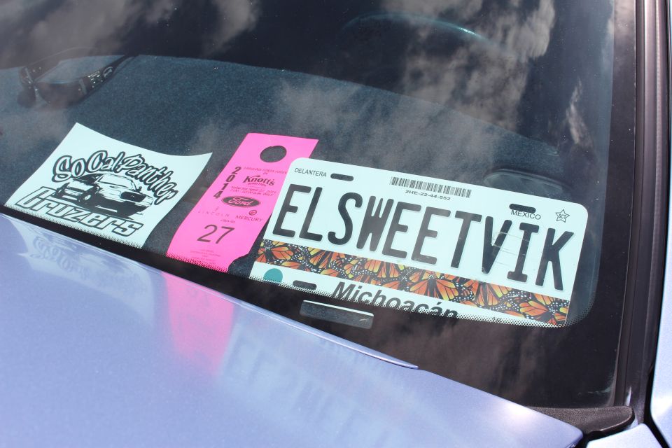 Close-up of Michoacan plate ELSWEETVIK and pink entry tag on a windshield