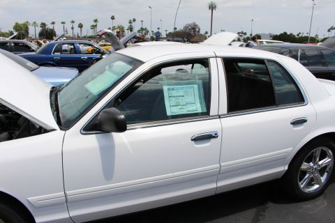 White sedan side profile with printed show display cards in the windows